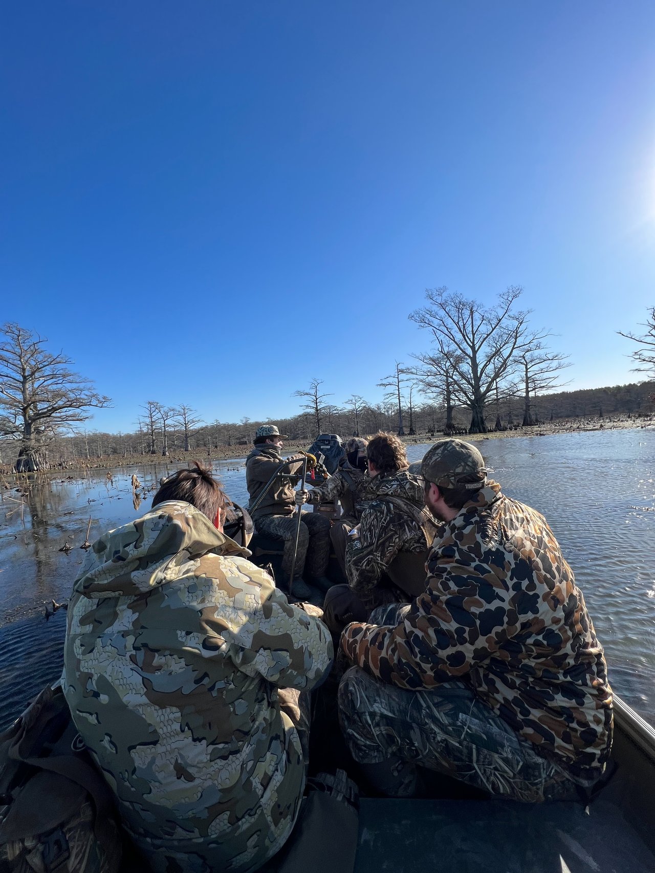 Men riding a boat to a hunting blind in arkansas