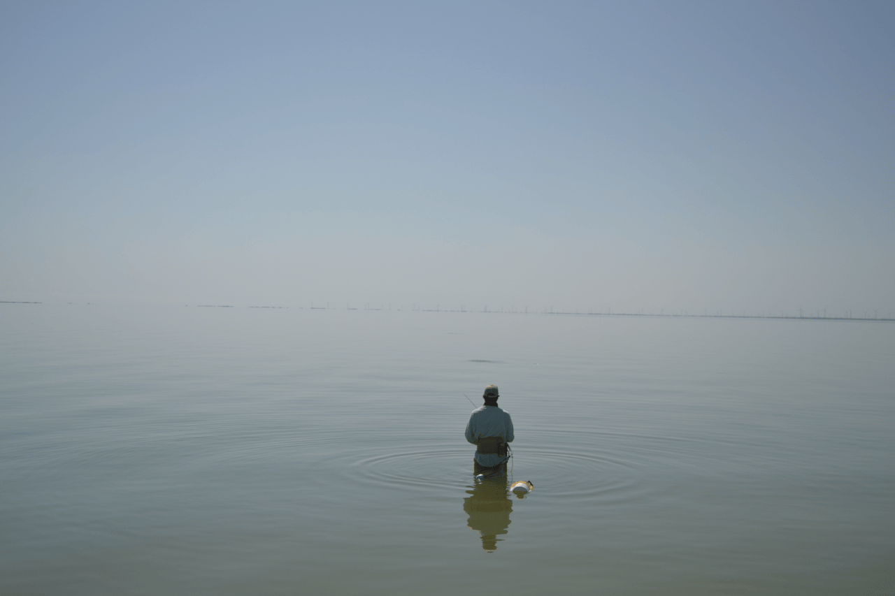 Man wading in water fishing for trout