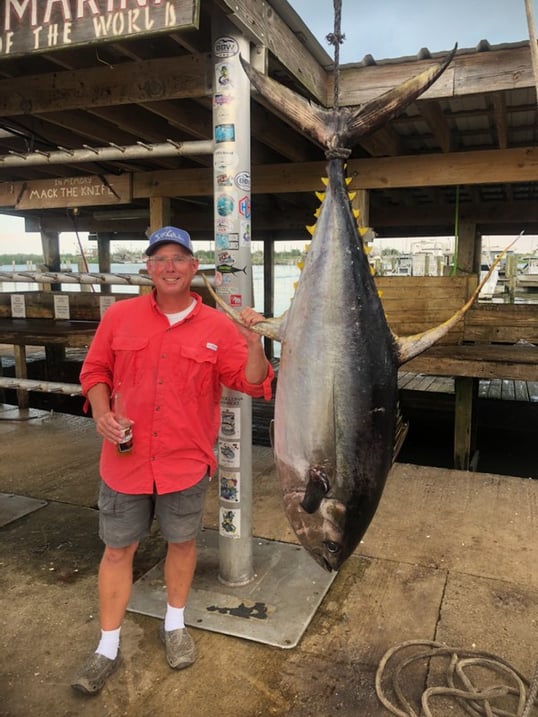 Man standing next to big yellowfin tuna.