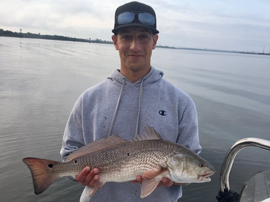 Man holding Redfish while fishing in Charleston